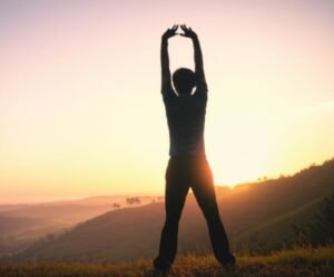 A person finding peace and hope at sunrise, symbolizing a new beginning with drug-free pain management.